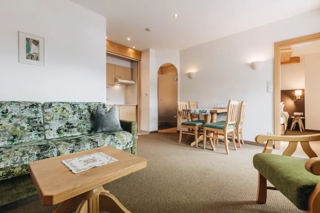 Gemütlicher Wohn- und Essbereich mit grünen Möbeln in einer hellen Ferienwohnung Seefeld.