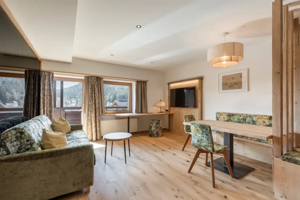 Moderner Wohn- und Essbereich in dieser ferienwohnung Seefeld mit Blumenmöbeln und Holzböden.