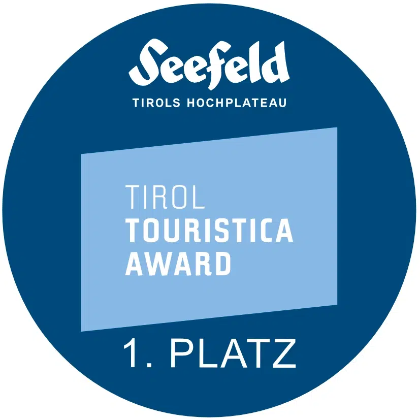 Blaue runde Plakette mit Seefeld Winterwandern und Tirol Touristica Award 1. Platz Text.
