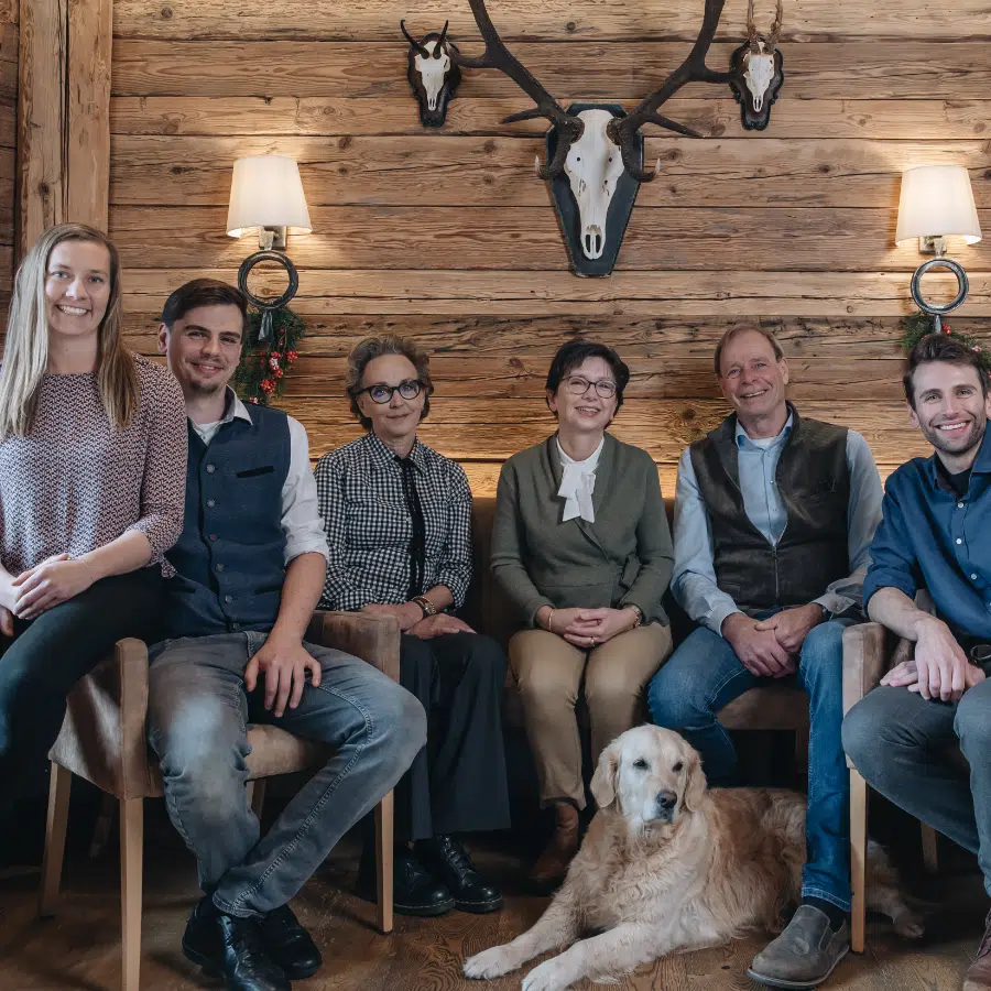 Sechs Personen und ein Golden Retriever-Lächeln in einem rustikalen Hotelzimmer mit Geweih im 4 Sterne Seefeld.