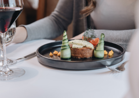 Ein Gourmetgericht mit Gemüse und Wein auf einem Restauranttisch.