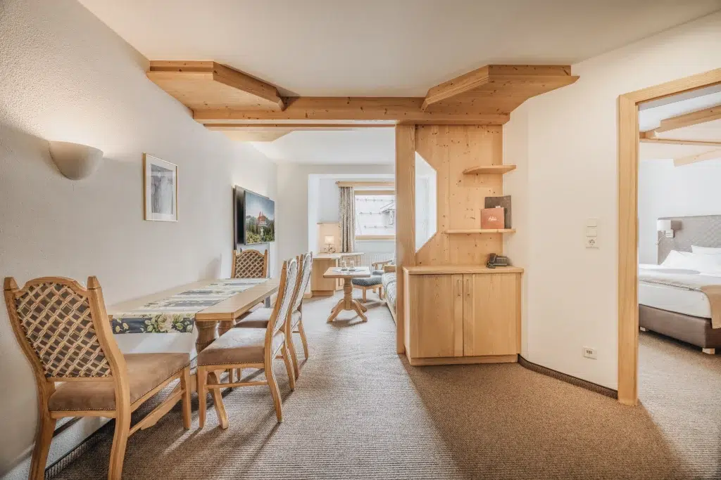 Gemütliche Ferienwohnung Seefeld Suite mit Holzmöbeln, Essbereich und separatem Schlafzimmer.
