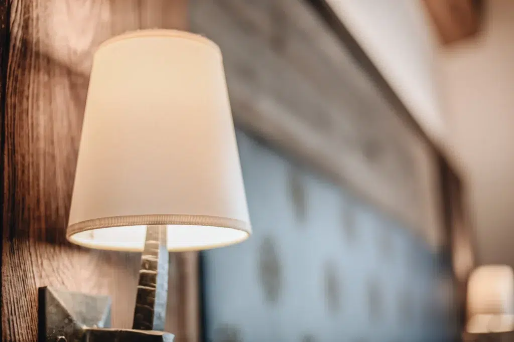 Eine Nahaufnahme einer Wandlampe in einem sanft beleuchteten Zimmer der Ferienwohnung Seefeld.