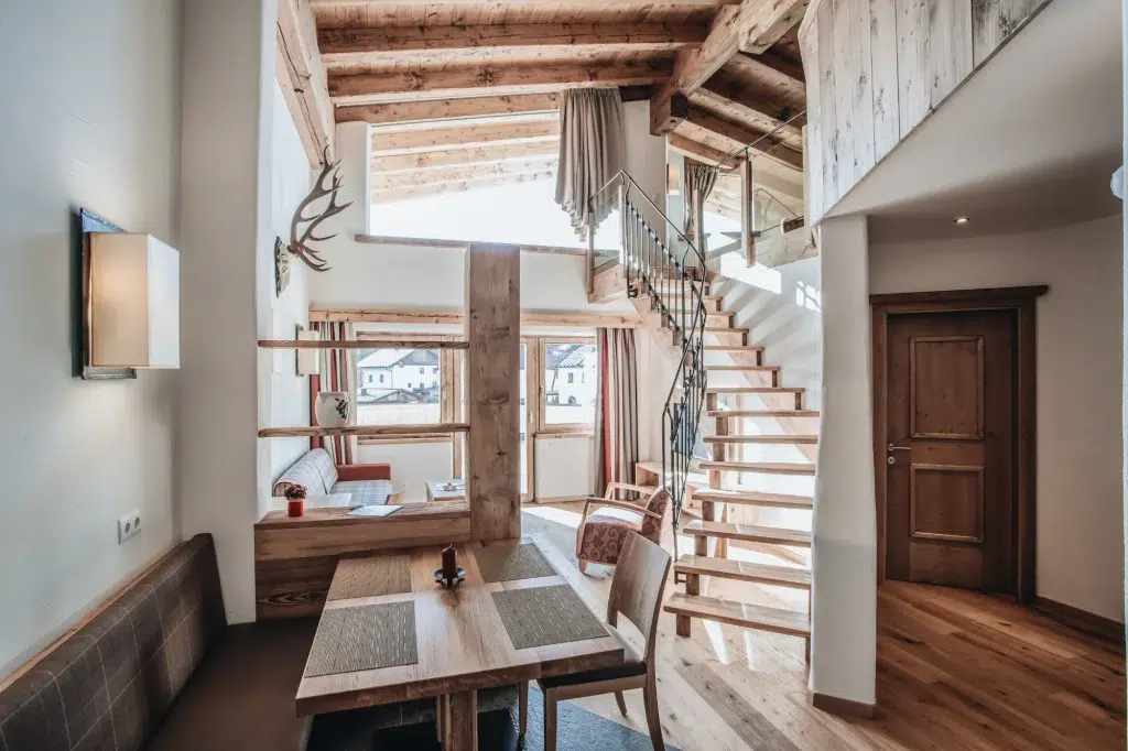 Gemütliche, moderne Ferienwohnung Seefeld Loft mit Holzakzenten, Essbereich und sonnendurchfluteten großen Fenstern.