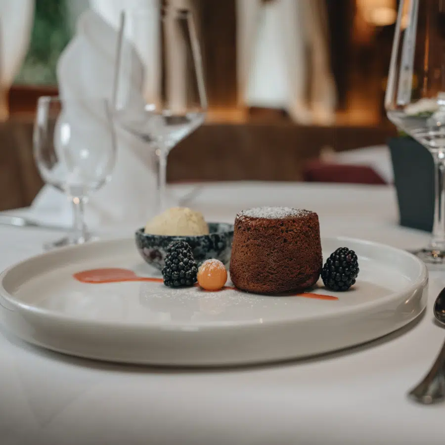 Schokoladen-Lavakuchen mit Beeren und Eis in einem Restaurant in Seefeld, elegant serviert.